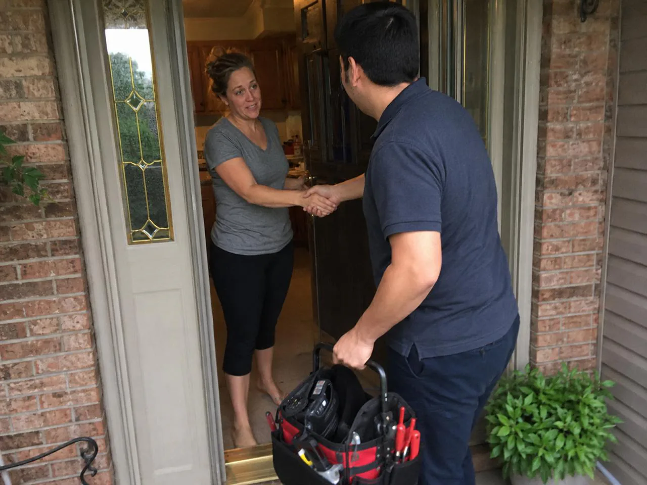 Technician greeting a homeowner at the front door