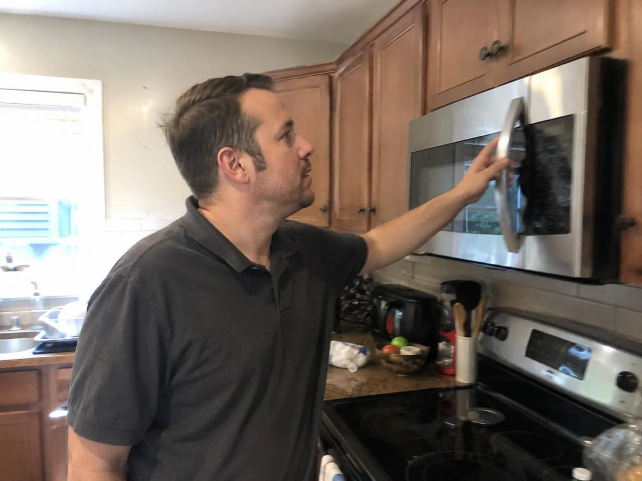 Technician servicing an over-the-range microwave